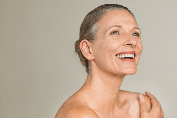 old patient smiling and showing facial aging in her face